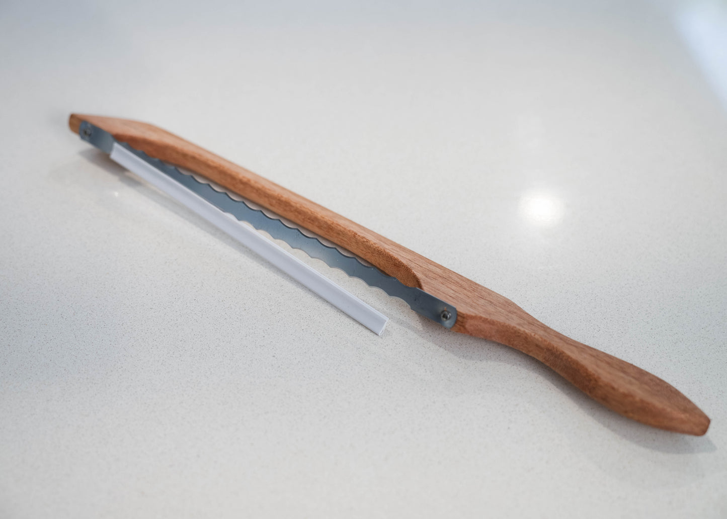 a wooden bread saw with a 2 sided blade for raigh and and left handed people