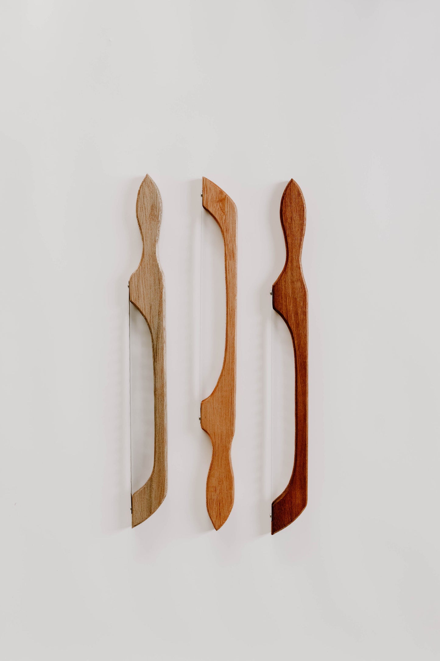 Handmade timber bread saws displayed in multiple natural colour variations
