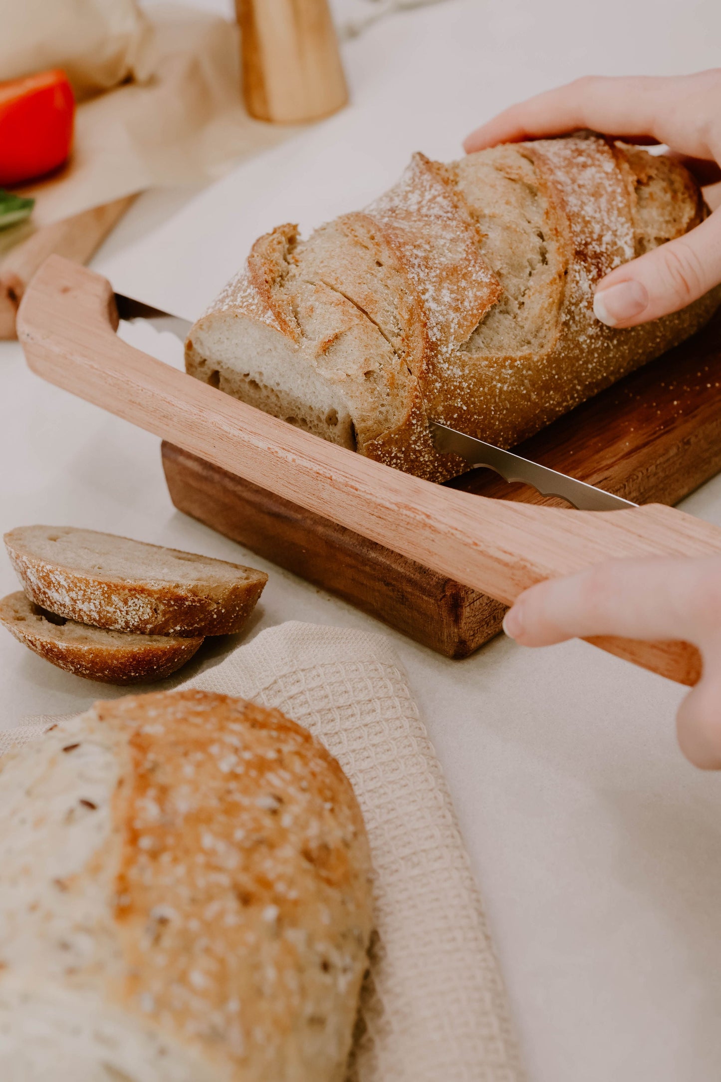 Left-handed Australian-made timber bread saw slicing cleanly through a crusty loaf