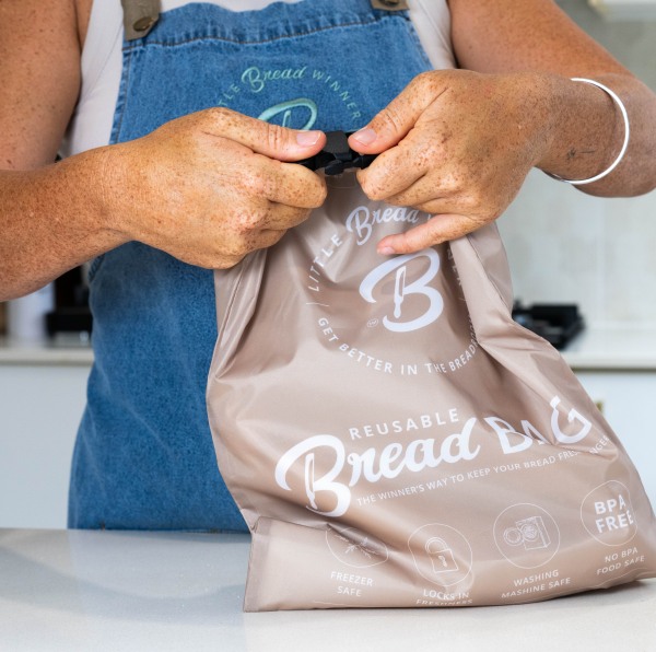 Person sealing reusable eco-friendly bread bag.