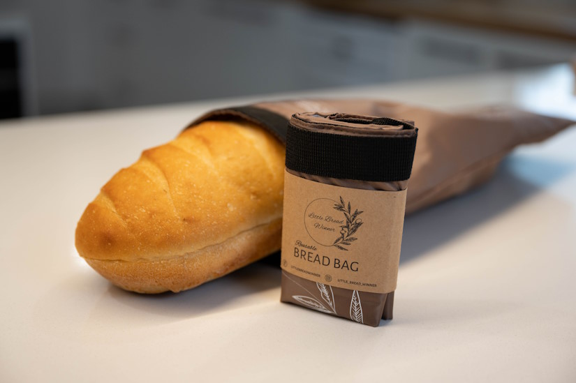 Little Bread Winner's Reusable Bread Bag and a loaf of fresh bread on a kitchen counter