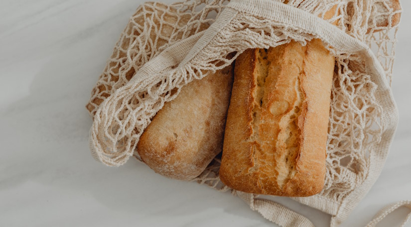 Reusable bread bag with fresh artisan bread.